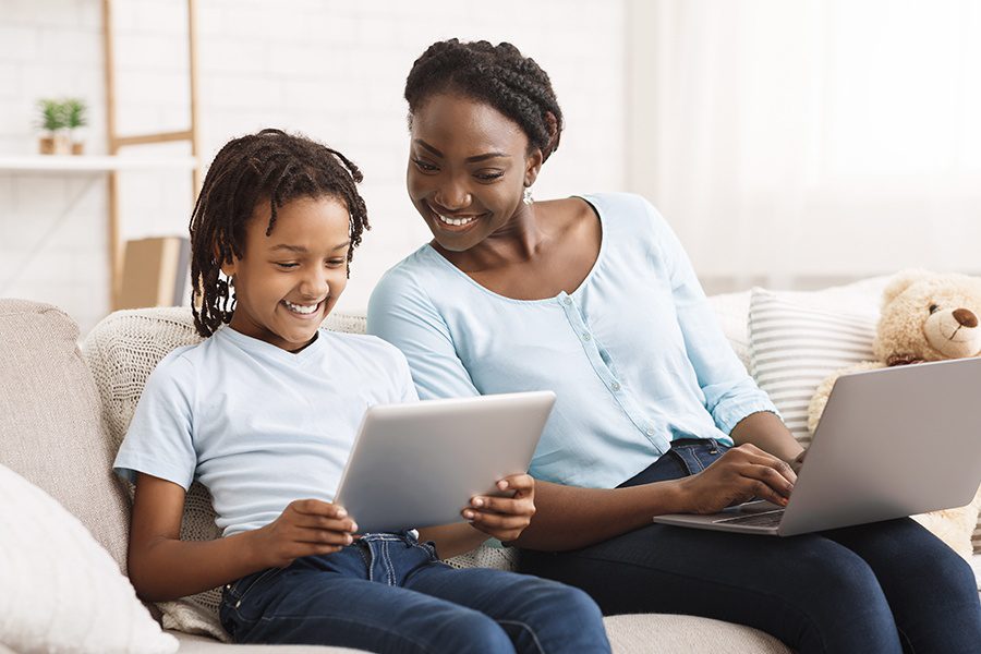 Blog - Mother and Daughter Doing Work on the Sofa at Home